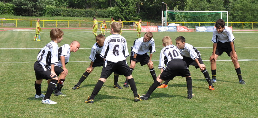 Grupa młodych piłkarzy na stadionie w czasie treningu.